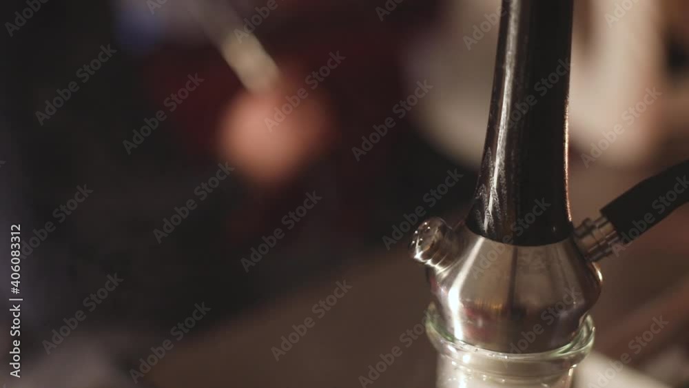 View of Hookah with candles and smoke on a table, hookah lounge with young people smoking in the background, shisha party club concept
View of Hookah with candles and smoke on a table, hookah lounge with young people smoking in the background, shisha party club concept