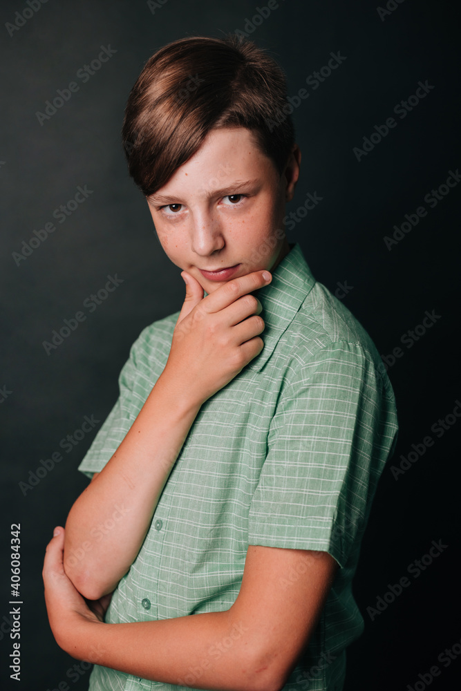 Teenager in a green T-shirt on a gray background. Teenager in a green T-shirt on a gray background.
