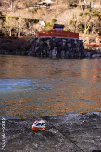 Daruma in front of a pond