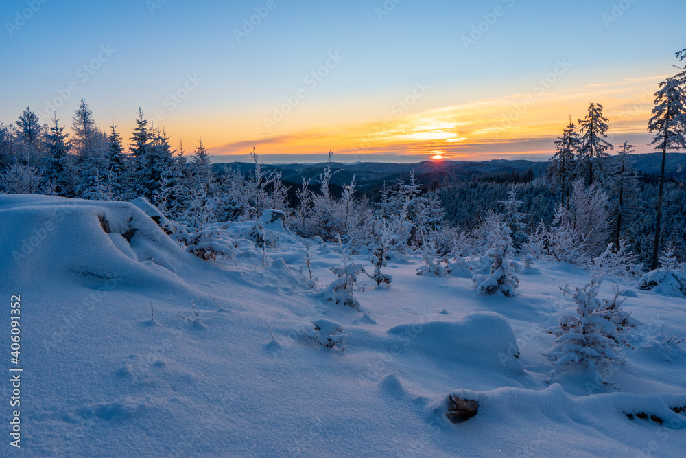 Frosty winter sunrise in mountain foresty with snow covered fir trees. Great outdoor scene, Happy New Year celebration concept. Artistic style post processed photo. Orton Effect.