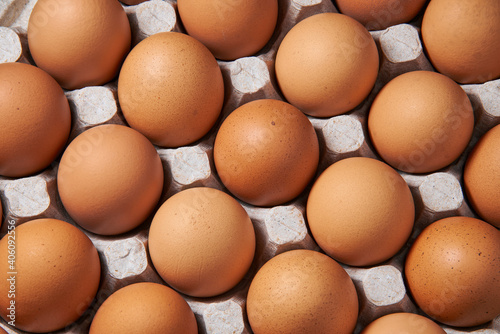 Brown chicken eggs lie in a cardboard egg tray, close-up, organic protein of natural origin, free space for text.