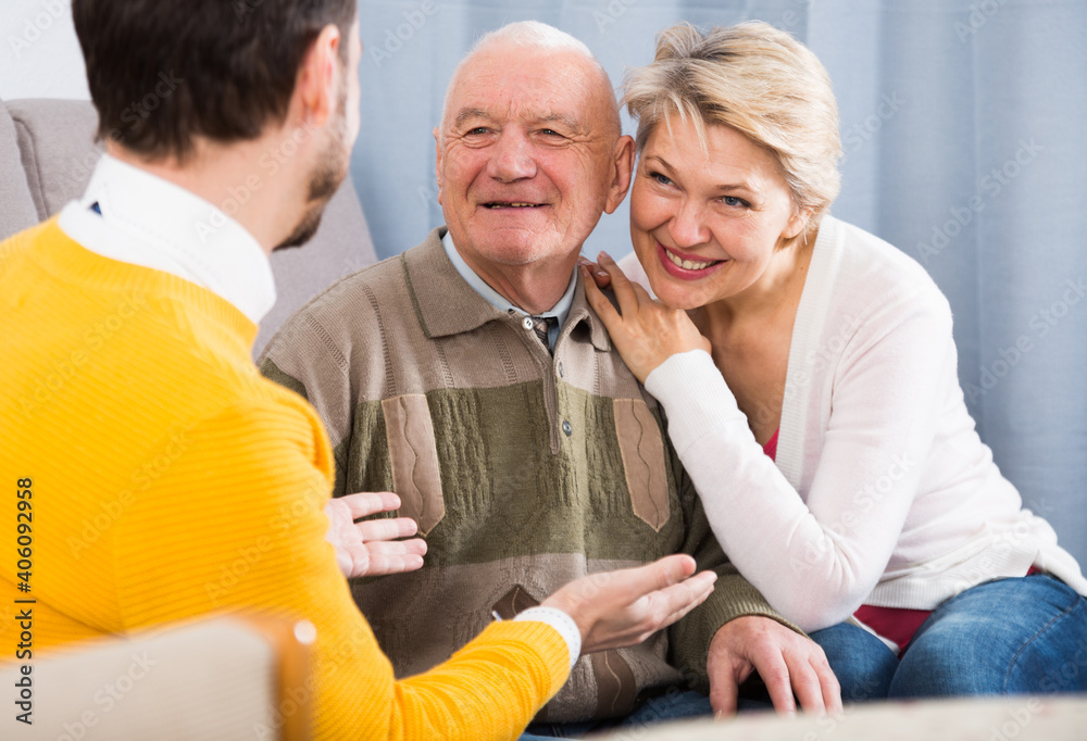 Obraz premium Aged grandfather and his daughter warmly communicate with his grandson at home