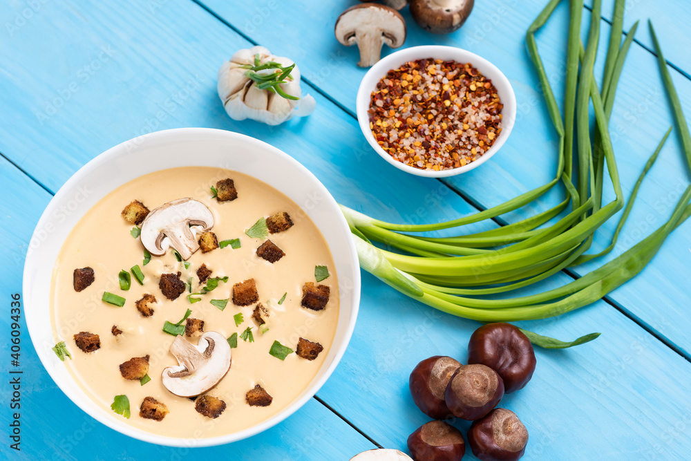 Chestnut soup on a wooden background with onions and garlic.