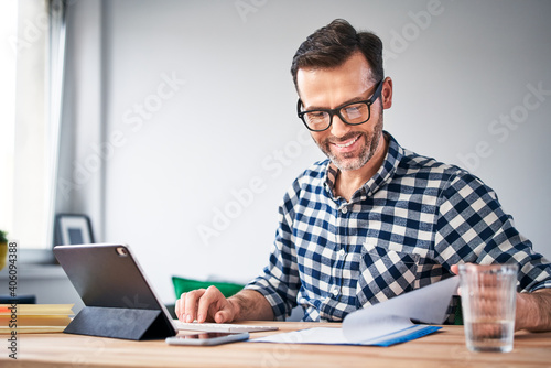 Smiling man working from home looking at documents