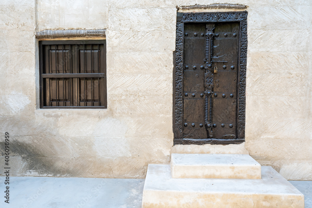 Ancient Museum doors and barred window of a middle eastern fort at the Ras al Khaimah Museum in the United Arab Emirates.