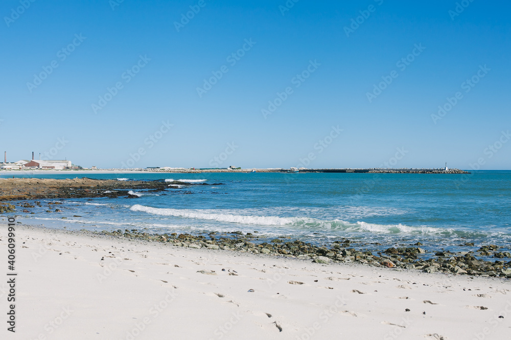 Beach with harbor wall on a sunny day. Landscape photo 