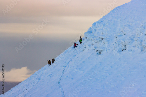 Skiers rest on the snow on a bright sunny day in the Brecon Beacons mountains