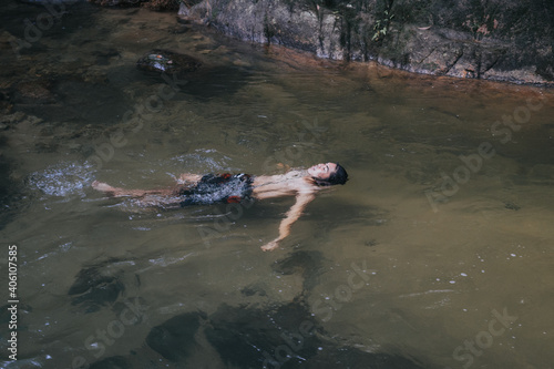 A male traveler in the rain forest pool stream or waterfall.Healthy and active lifestyle.Camping and hiking.