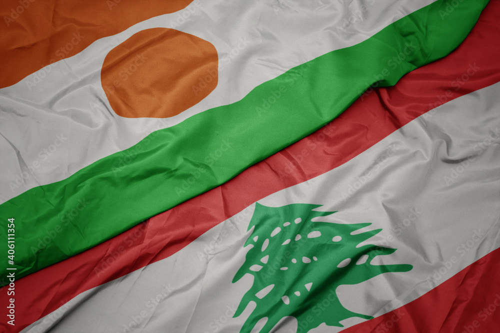 waving colorful flag of lebanon and national flag of niger.