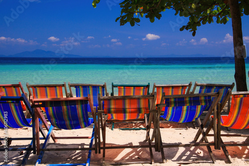 View on isolated colorful empty deck chairs in a row on tropical beach  Thailand  Ko Phi Phi - tourism industry perspective concept
