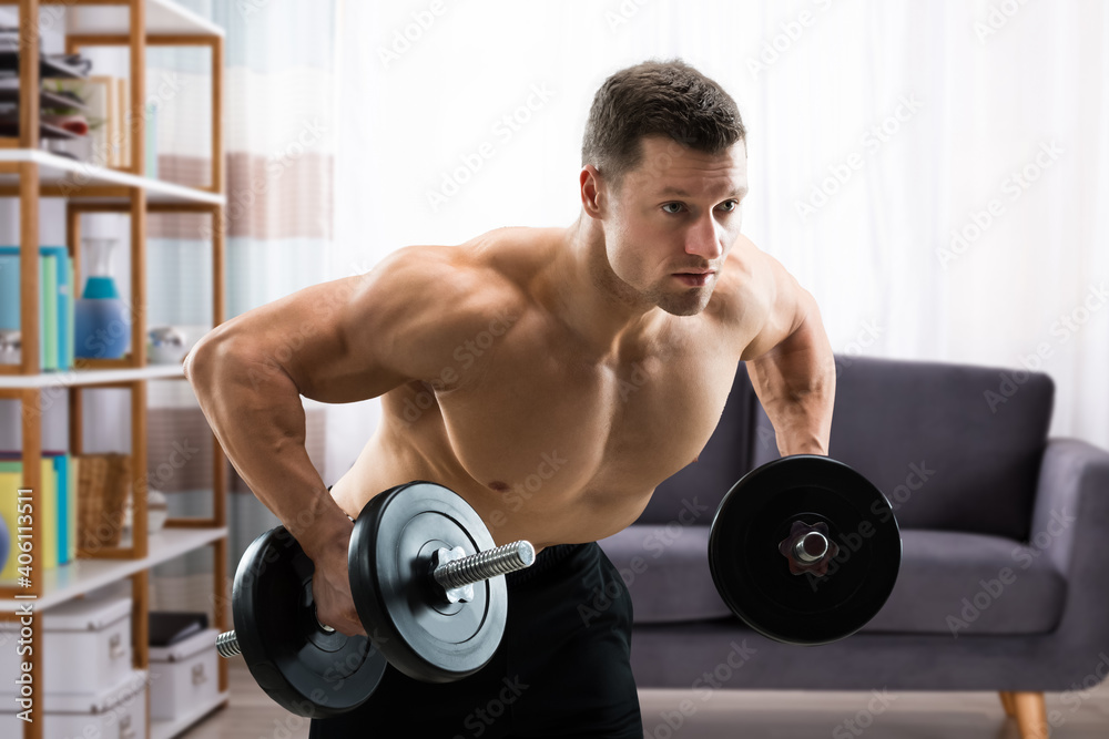 Determined Muscular Man Lifting Dumbbells Determined Muscular Man Lifting Dumbbells
