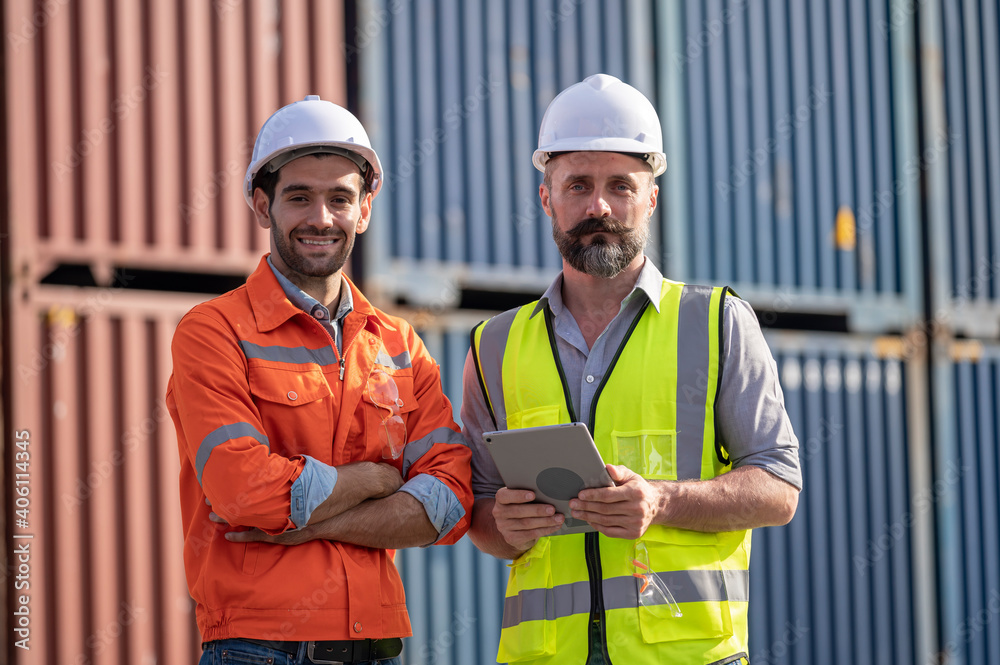 Logistics engineer and inspector working togetter and discussing in shipping containerin commercial transport port Logistics engineer and inspector working togetter and discussing in shipping containerin commercial transport port