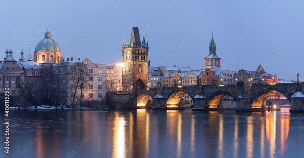 .Charles Bridge on the Vltava River and statues on the bridge and light from the street lights and a fallen dream in winter in the early evening in the center of Prague