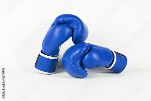 Blue boxing gloves on a light background lie on top of each other - winner and loser, concept of sports, boxing