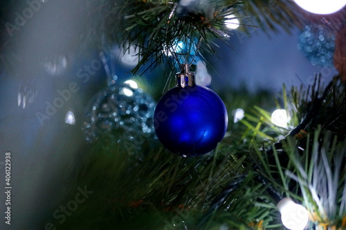 Beautiful blue christmas ball hanging on the branch of a christmas tree