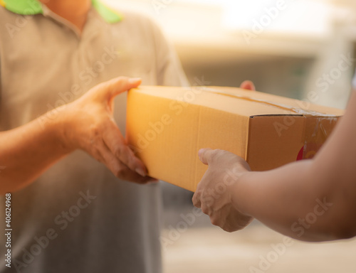 Delivery man by sending box of parcel to customers service at home