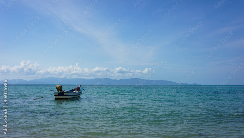Boat in a blue sea and blue sky with white cloud