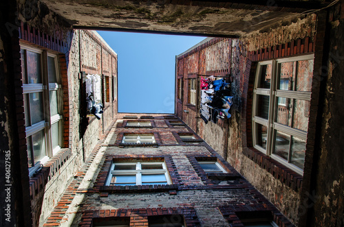 Fototapeta Naklejka Na Ścianę i Meble -  Widok do góry starych kamienic z rozwieszonym praniem, Gdańsk Dolne Miasto