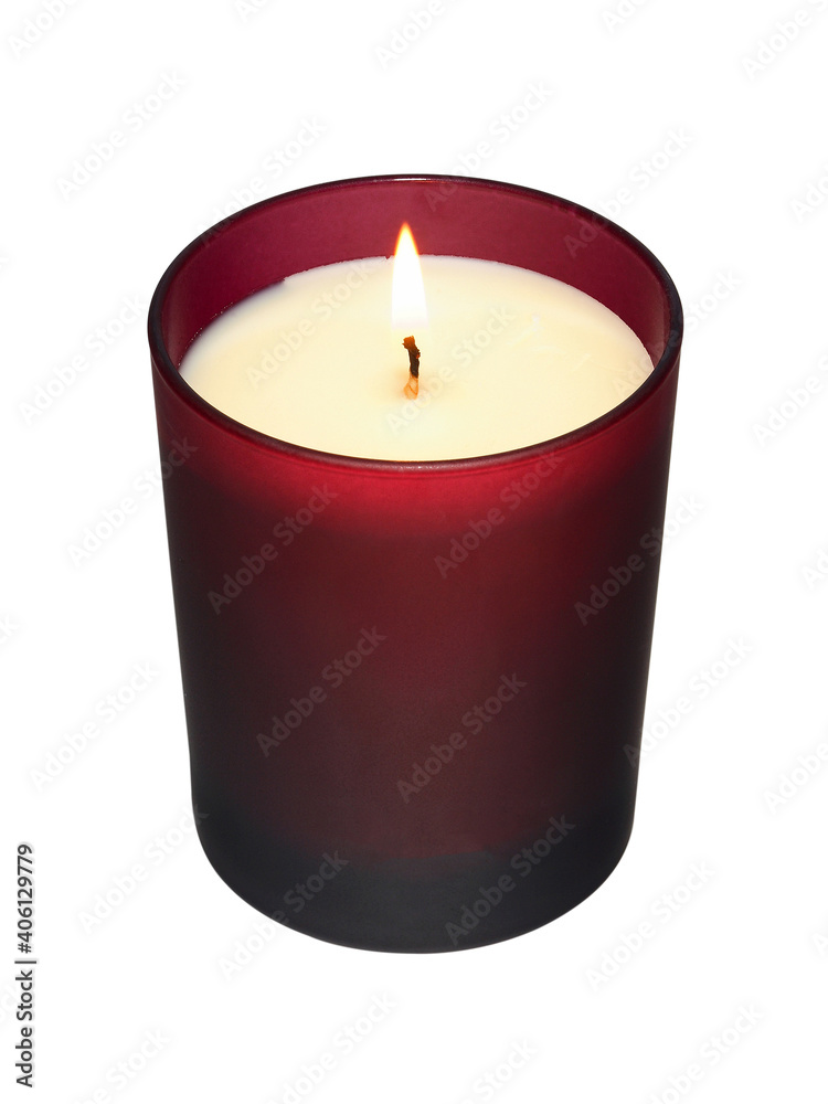 White burning candle in red glass on white background