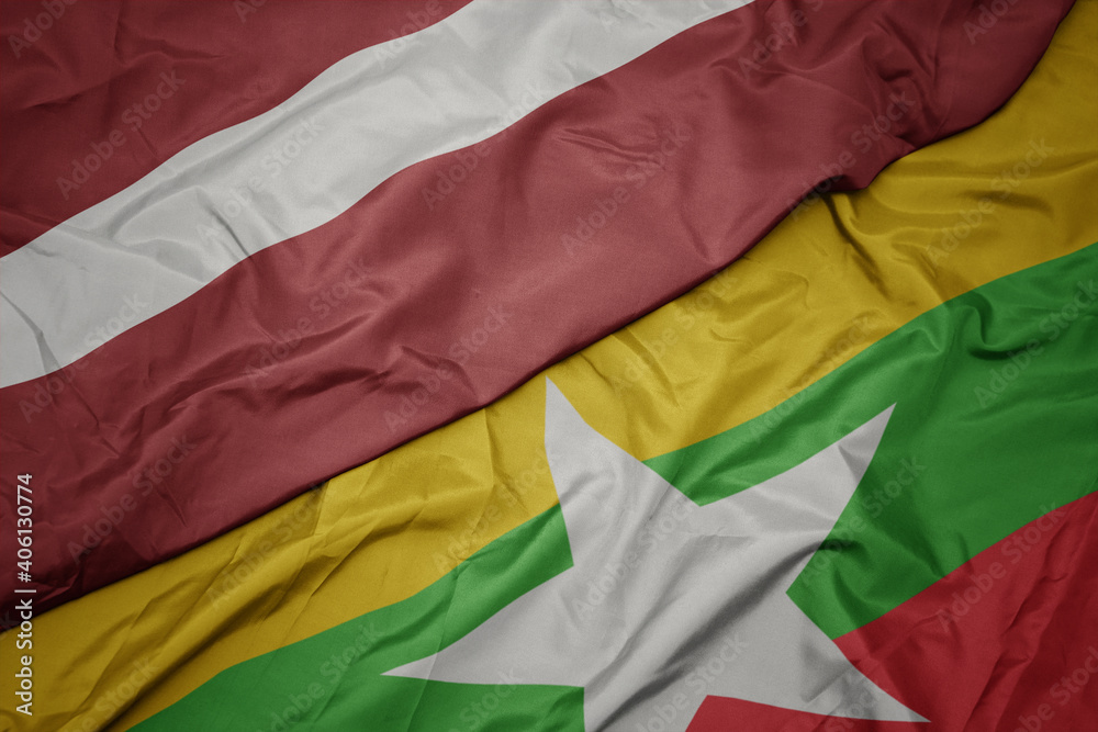 waving colorful flag of myanmar and national flag of latvia