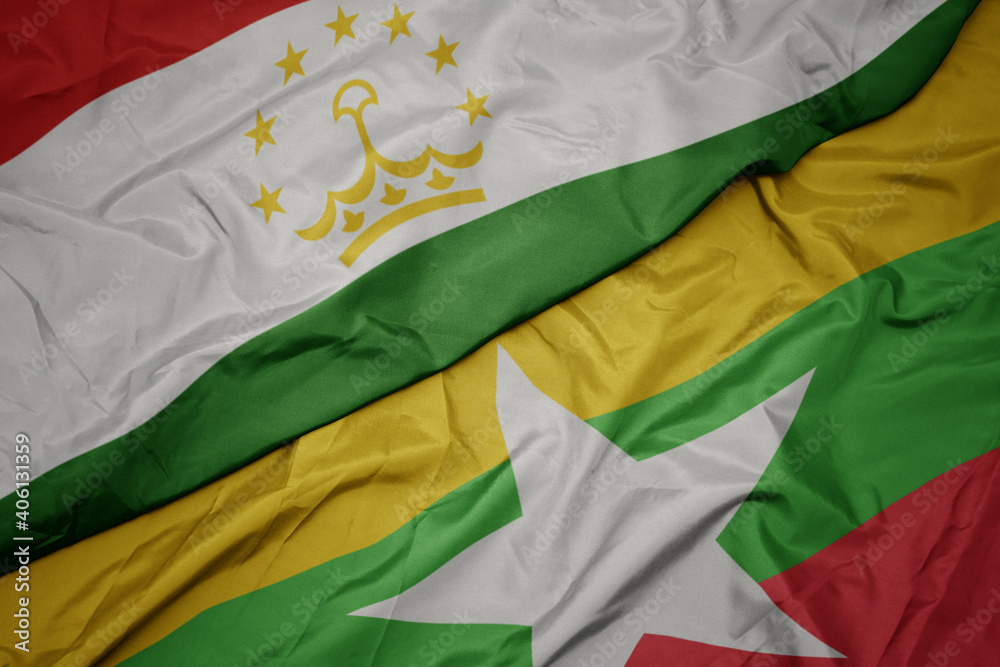 waving colorful flag of myanmar and national flag of tajikistan. waving colorful flag of myanmar and national flag of tajikistan.