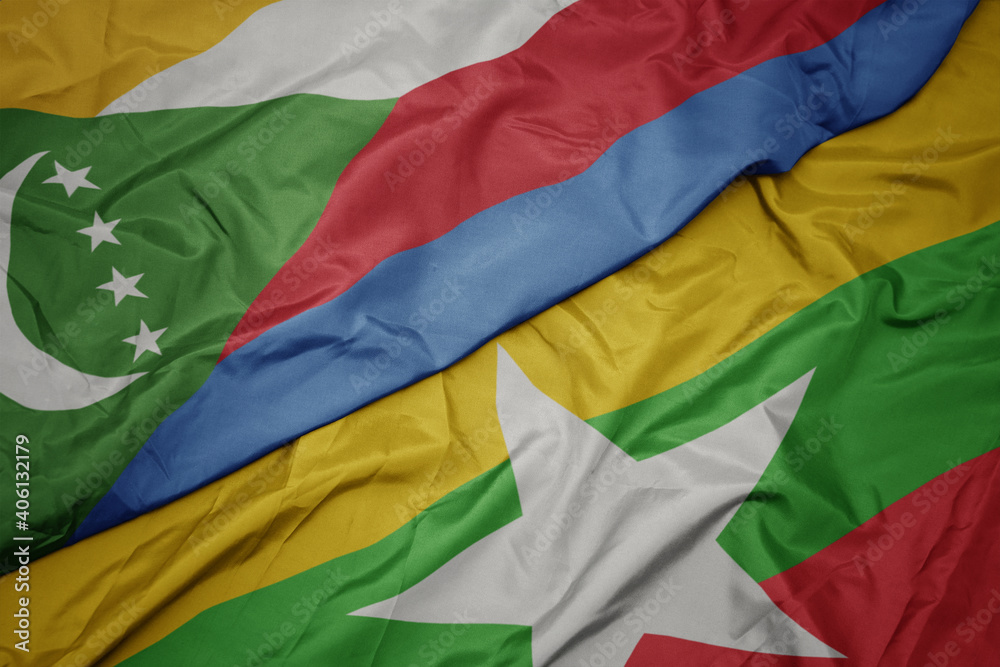 waving colorful flag of myanmar and national flag of comoros.