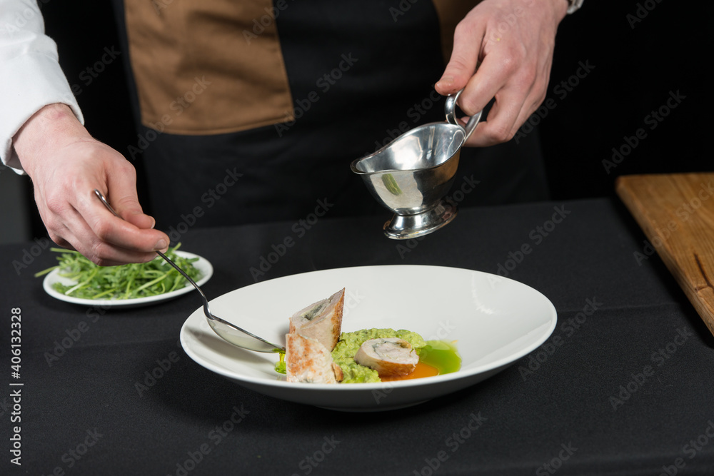 The chef prepares a serving of meatloaf. Pour the sauce over the dish. black tablecloth The chef prepares a serving of meatloaf. Pour the sauce over the dish. black tablecloth