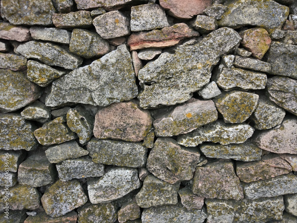 Fototapeta premium Old grey stone wall of different size bricks