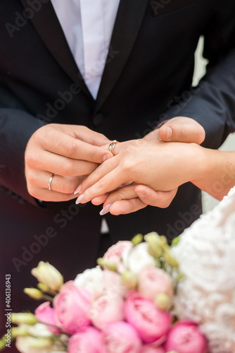 wedding rings and hands of bride and groom. young wedding couple at ceremony. matrimony. man and woman in love. two happy people celebrating becoming family