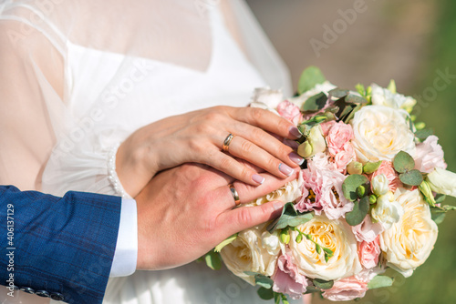 newlyweds ' hands with rings. Wedding bouquet on the background of the hands of the bride and groom with a gold ring