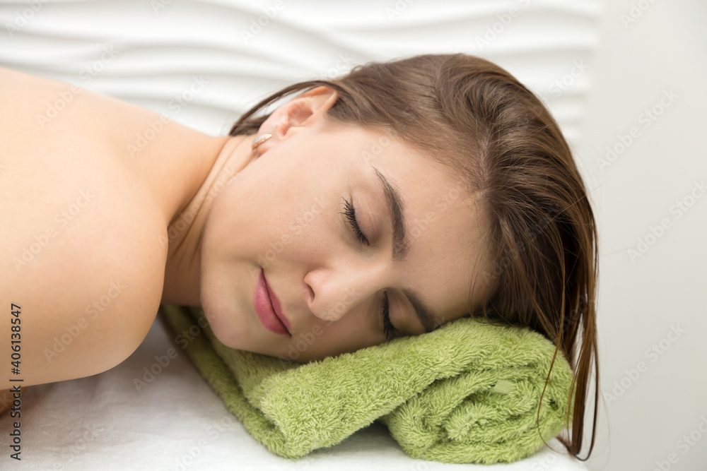 Young woman resting in massage parlor, put her head on a towel. Young woman resting in massage parlor, put her head on a towel.