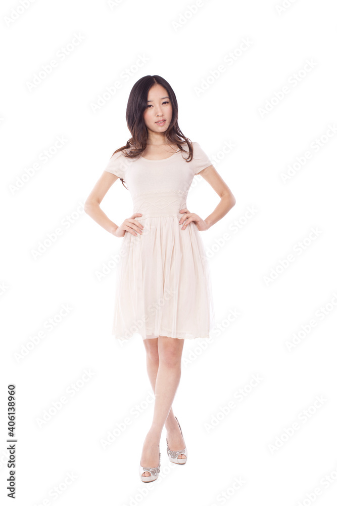 Young woman in cocktail dresses with hands on hips