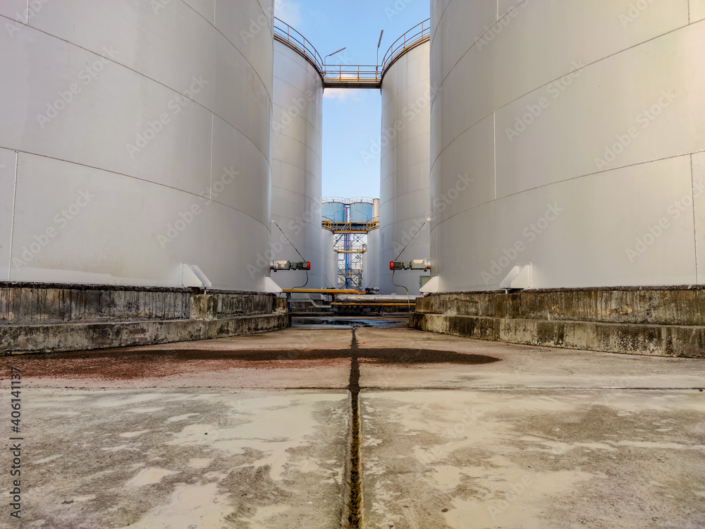 Obraz premium Oil storage tank, water tank In industrial areas. Crude oil storage plant For export. Palm oil factories in Asia. The atmosphere at sunset. Within the industrial plant 