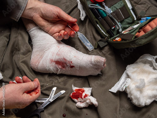 Bandaging process. First aid kit and items for stopping bleeding