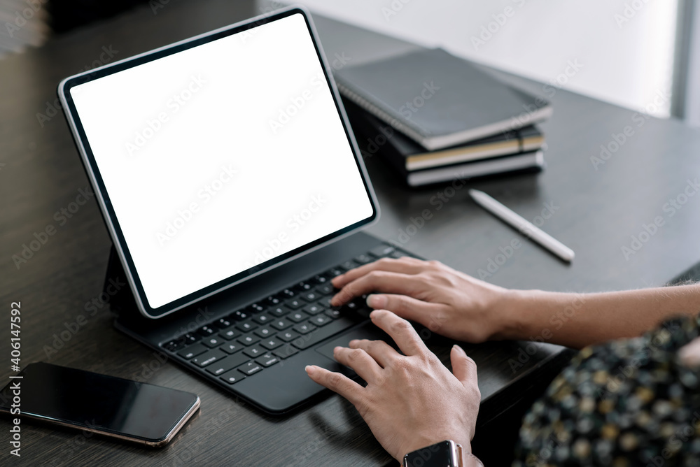 Close up. Woman hand typing on digital tablet keyboard with blank screen on desk at office. Close up. Woman hand typing on digital tablet keyboard with blank screen on desk at office.