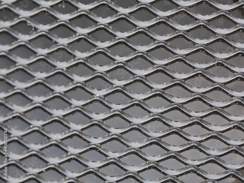 Texture in the form of rhombuses. Black metal mesh.