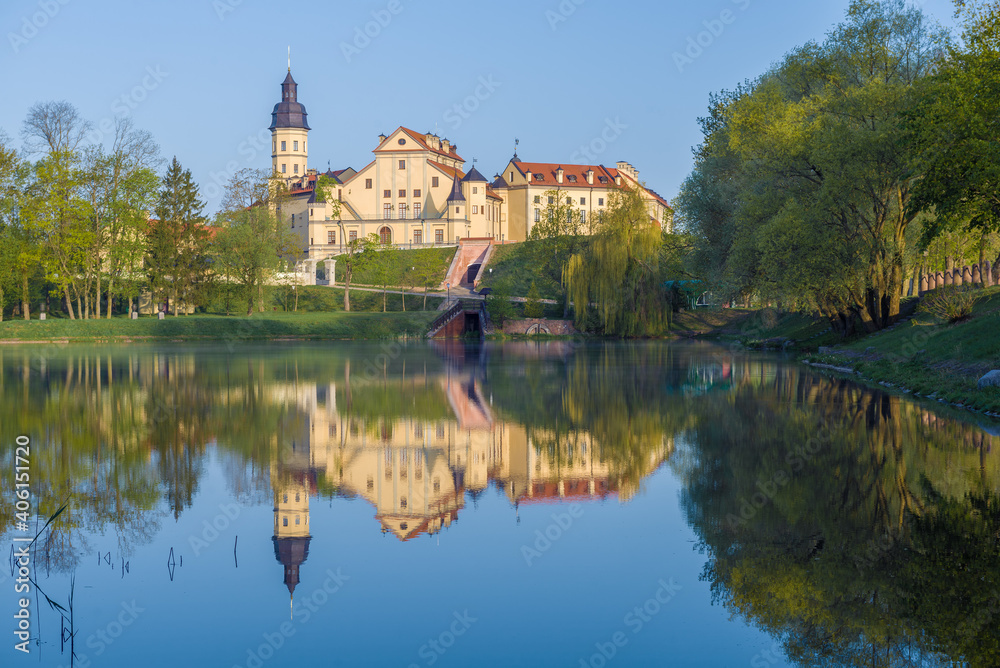 View of the Nesvizh Castle from the side of the Castle Pond on a sunny May morning. Belarus