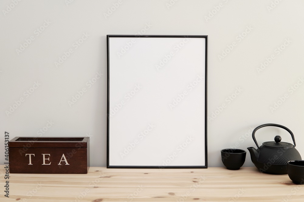 Fotka „Kitchen wall art frame mockup, empty black frame on kitchen table,  tea pot and cups.“ ze služby Stock | Adobe Stock