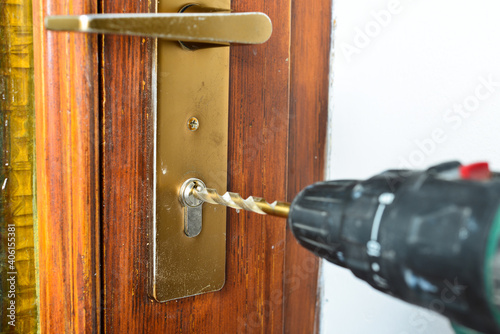Drill open the old front door with a locksmith