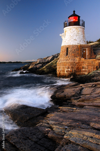 Waves crash on the shore at dusk at the Castle Hill Lighthouse in Rhode Island