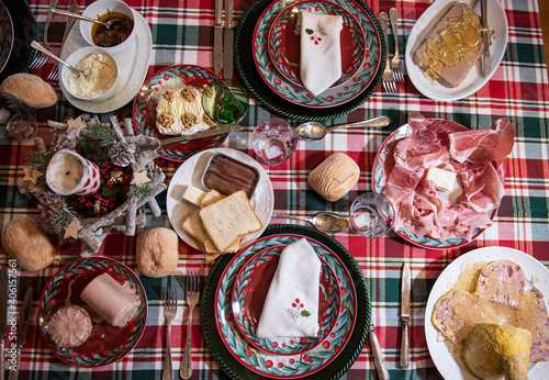 tavola da pranzo apparecchiata per festa natalizia vista dall'alto con colori vibranti e cibarie  photo