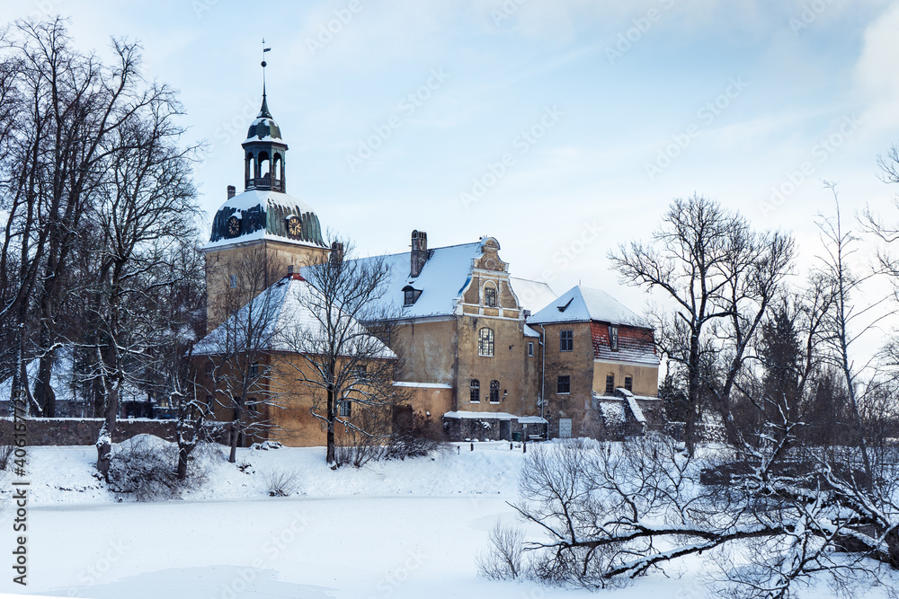 The building complex of an old large German manor located in Latvia is snow-covered in winter