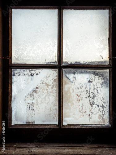 Wooden windows with frozen glass where there is a view to the outside when a sunny day