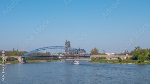 Panoramic view over downtown of Magdeburg, old town, Elbe river, bridges and Magnificent Cathedral at early Spring, Germany, at sunny day and clear blue sky with a tour boat.