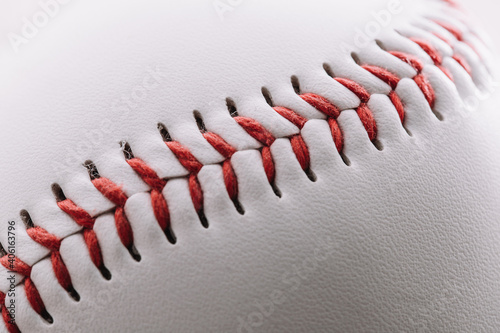 Close-up of a red thread seam on a white leather baseball - macro shot
