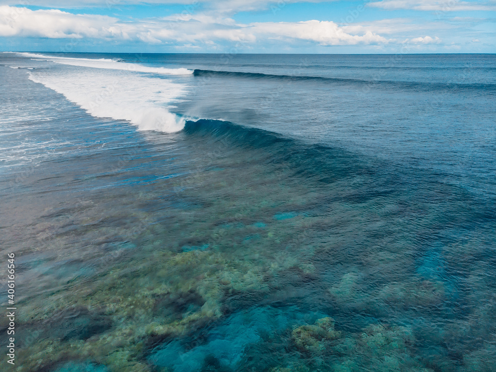 Blue barrel wave in tropical ocean. Aerial view of surfing barrel waves