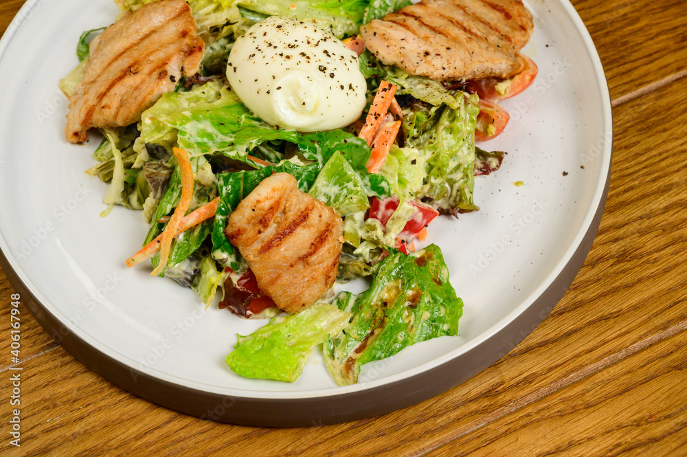 Caesar salad with croutons, quail eggs, cherry tomatoes and grilled chicken in wooden table Caesar salad with croutons, quail eggs, cherry tomatoes and grilled chicken in wooden table