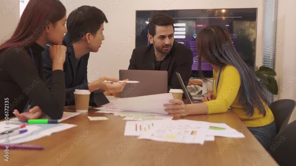 Young Asian woman leading business creative team in mobile application software design project.Meeting of UX developer and UI designer brainstorming about mobile app interface workflow design. Young Asian woman leading business creative team in mobile application software design project.Meeting of UX developer and UI designer brainstorming about mobile app interface workflow design.
