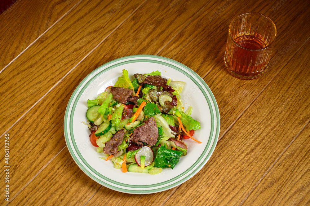 Fried meat with vegetables. Salad with meat, tomatoes, peppers, cucumbers and salad