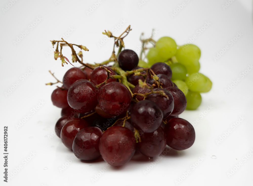 Fresh red and green grapes isolated on white background. Selective focus on the fresh red and green grapes. Fresh red and green grapes isolated on white background. Selective focus on the fresh red and green grapes.